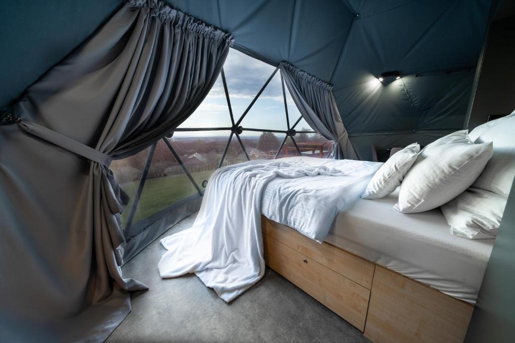 a bed in a tent with a window at Beskid Glamp in Jaworze