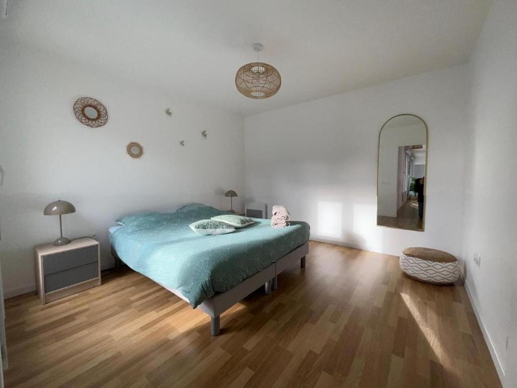シャン・シュル・マルヌにあるAppartement Cosy Champs sur Marneのベッドルーム1室(ベッド1台、壁掛け鏡付)