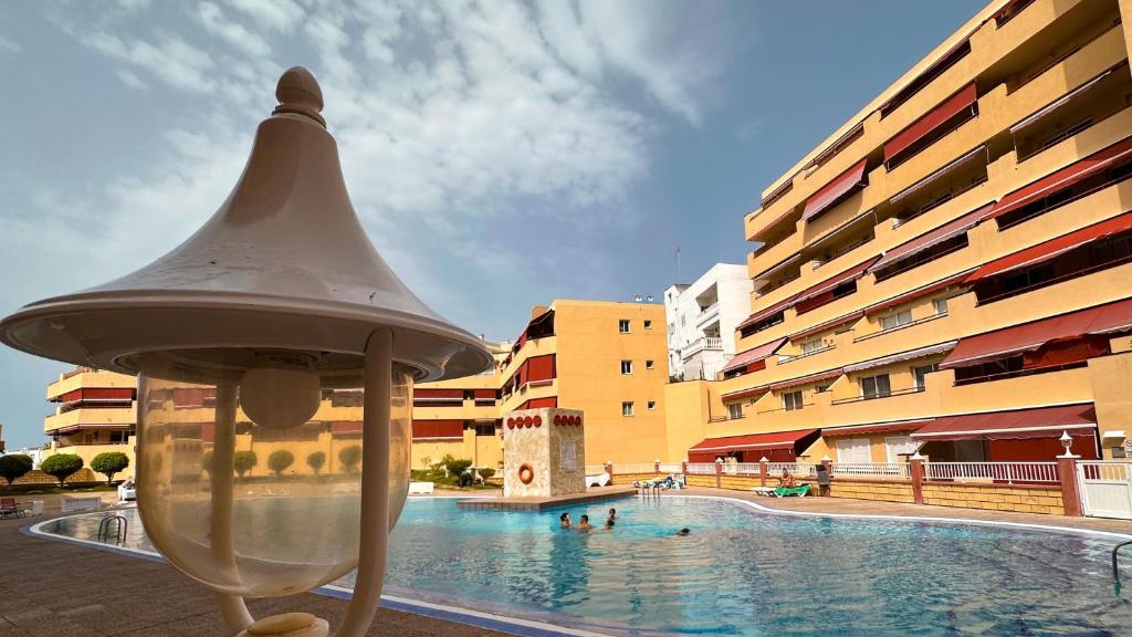 ein Schwimmbad mit Menschen im Wasser in der Unterkunft los Gigantes Jardines del Mar in Puerto de Santiago