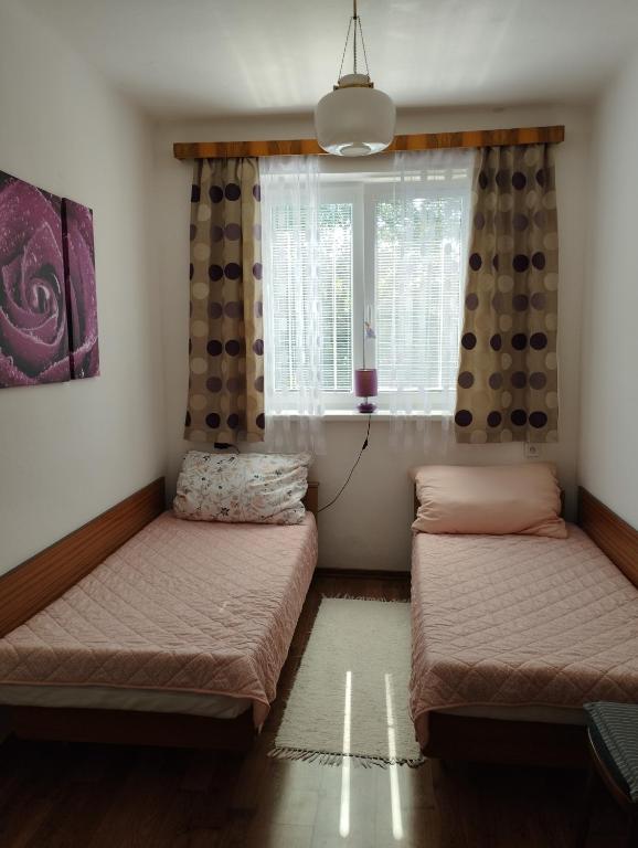 two beds in a room with a window at Apartman Veronika v rodinnom dome in Snina