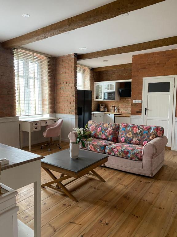 a living room with a couch and a kitchen at Apartments PSD - Wojska Polskiego 6 in Słupsk