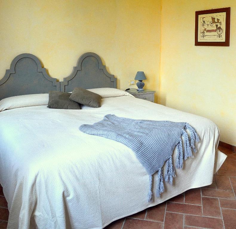 - une chambre avec un grand lit blanc et une couverture bleue dans l'établissement Agriturismo Borgo San Francesco, à Basiglio
