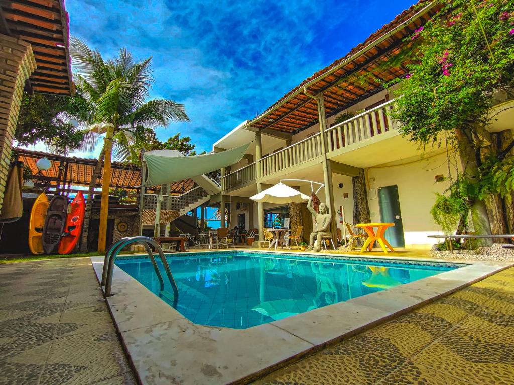 a swimming pool in front of a house at Pousada Água de Fuego in Maragogi