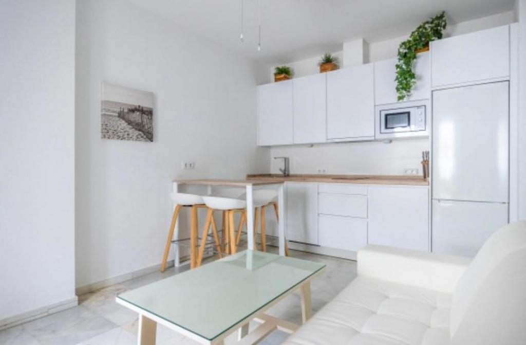 una cucina bianca con tavolo e frigorifero di Zahara 3 minutos playa a Zahara de los Atunes