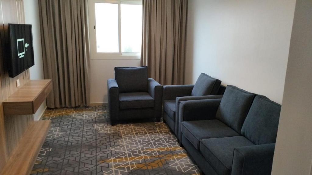 ein Wohnzimmer mit einem Sofa und 2 Stühlen in der Unterkunft GOLDEN NEW UMU ALQURAA Hotel in Dschidda