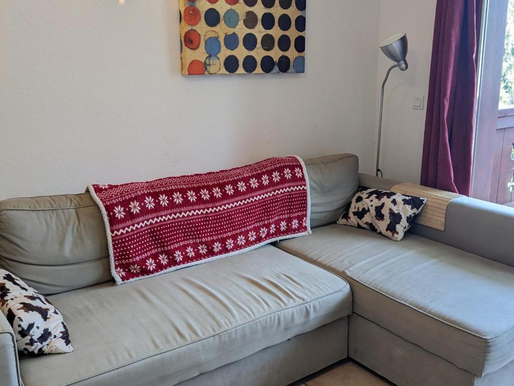 um sofá com um cobertor vermelho em cima em Appartement Les Adrets-Prapoutel, 3 pièces, 6 personnes - FR-1-557-121 em Les Adrets