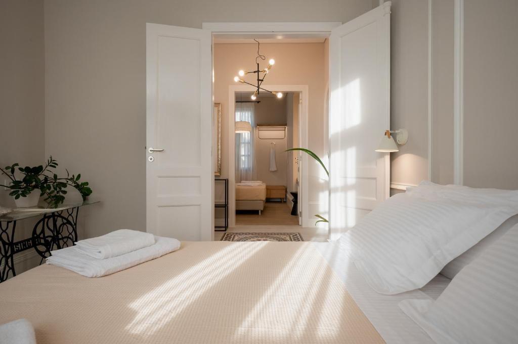 a white bedroom with a white bed and a hallway at Villa Kalliopi in Chania Town
