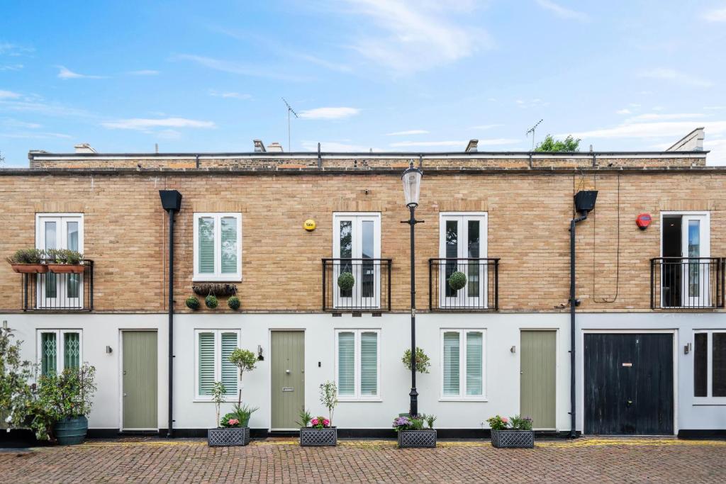 un edificio de ladrillo con puertas y ventanas blancas en Captivating 3-Bed House in London Holland Park en Londres