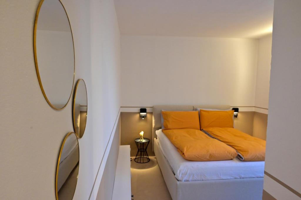una camera da letto con letto, cuscini gialli e specchio di Jrooms - Apulian Home a Tricase