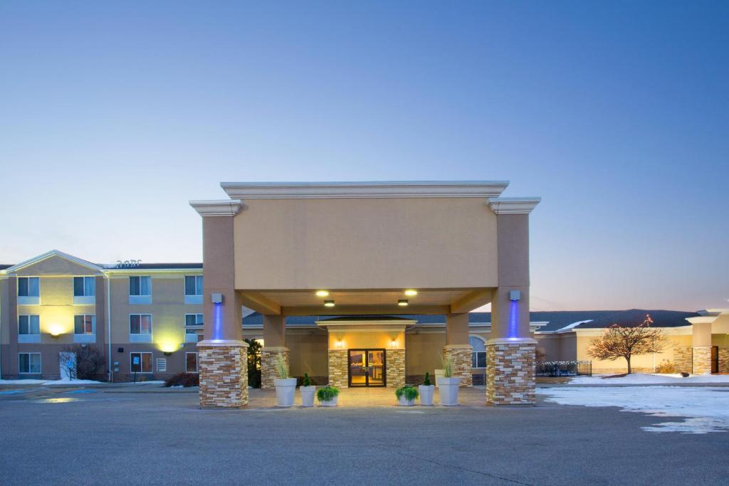 ein Hotelgebäude mit blauen Säulen auf einem Parkplatz in der Unterkunft Holiday Inn Express Hotel & Suites Lexington, an IHG Hotel in Lexington