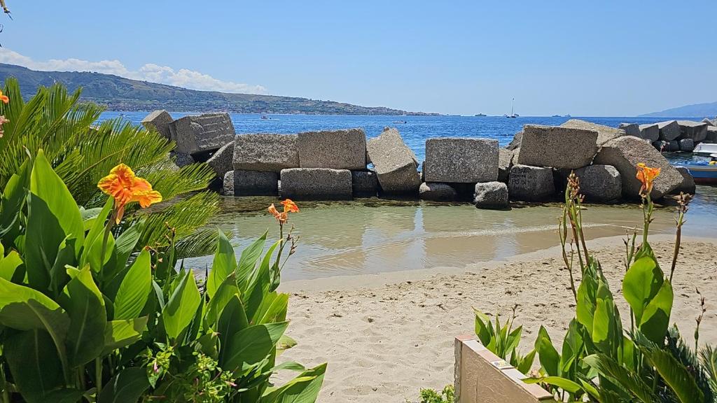 een strand met rotsen in het water bij Casa di Nonna Mariella in Messina