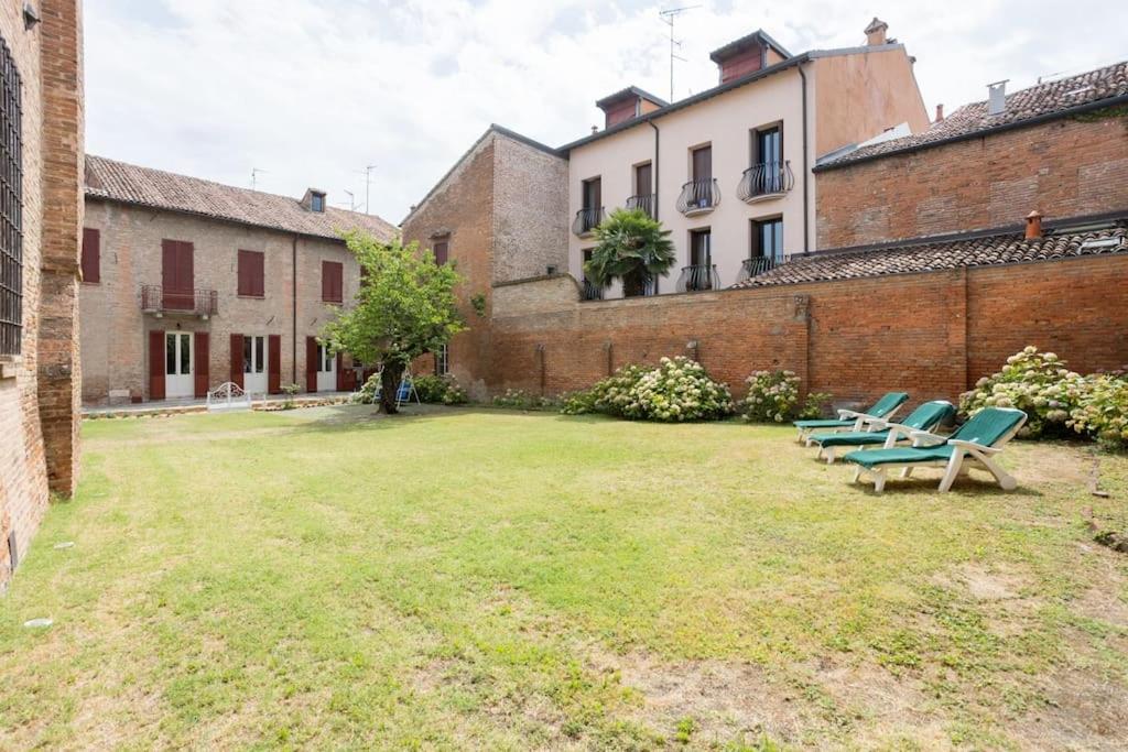 un gruppo di sedie seduti nel cortile di un edificio di PALAZZO SABBIONI APPARTAMENTO LUSSO due CAMERE SOGGIORNO CUCINA a Ferrara