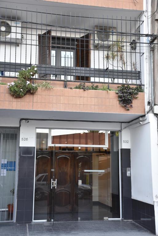 聖薩爾瓦多德胡胡伊的住宿－Departamento Balcarce Jujuy 4B，两扇门和两棵植物的建筑物入口