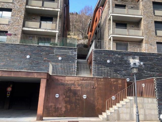 ein Gebäude mit Garage und Treppe davor in der Unterkunft Residencial Sol i Ski 24 4p Ransol El Tarter Zona Grandvalira in Sant Pere