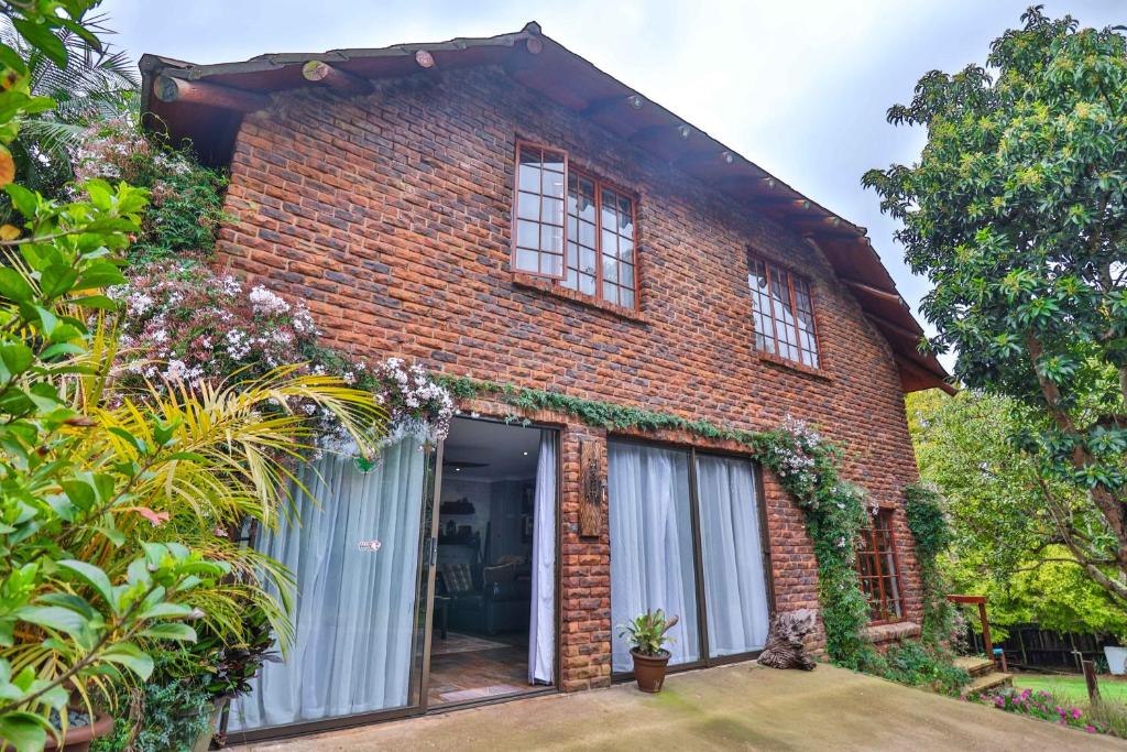 uma casa de tijolos com janelas e plantas em CASTLE COTTAGE Self catering fully equipped homely 120sqm double story king bed cottage in a lush green neighborhood em Hillcrest