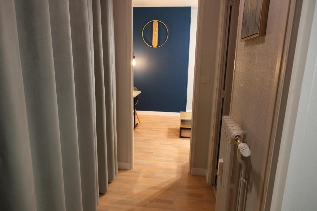 a hallway leading to a room with a blue wall at Le Jockey - SIPCO Immobilier - Centre in Saint Lo