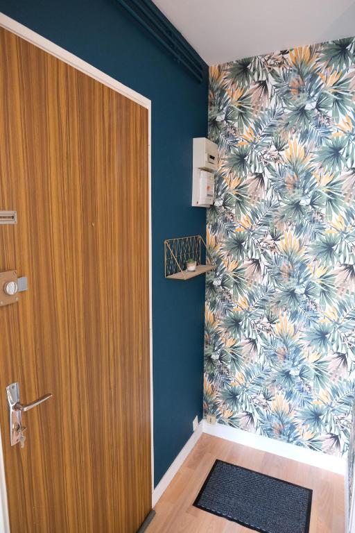 a room with a door and a floral wall at Le Jockey - SIPCO Immobilier - Centre in Saint Lo