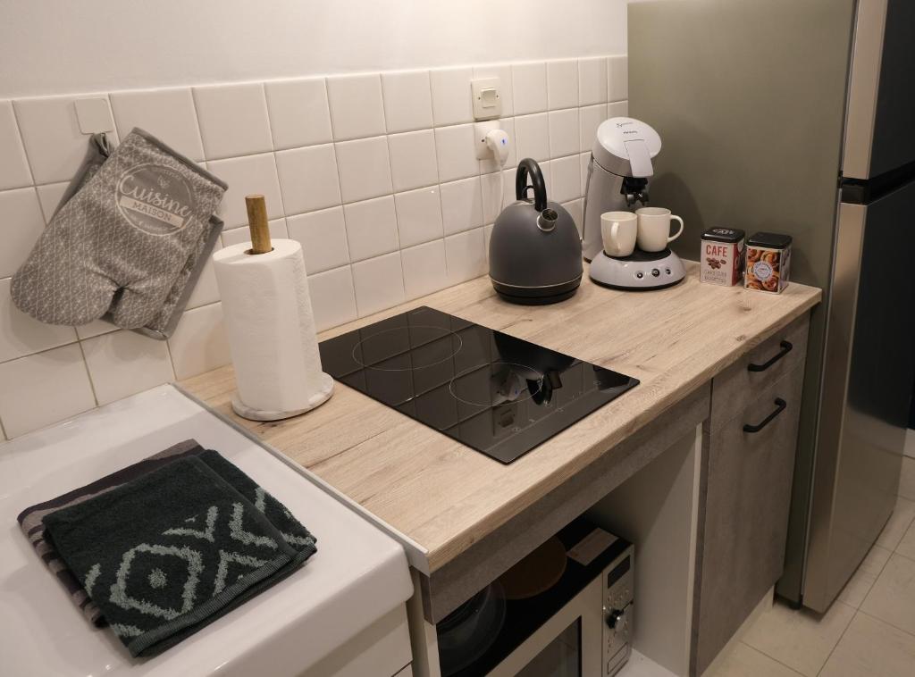 a kitchen with a counter with a stove top oven at Le Jockey - SIPCO Immobilier - Centre in Saint Lo