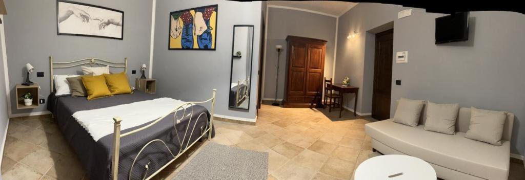 sypialnia z łóżkiem i kanapą w obiekcie Agriturismo San Marco w mieście Dragoni