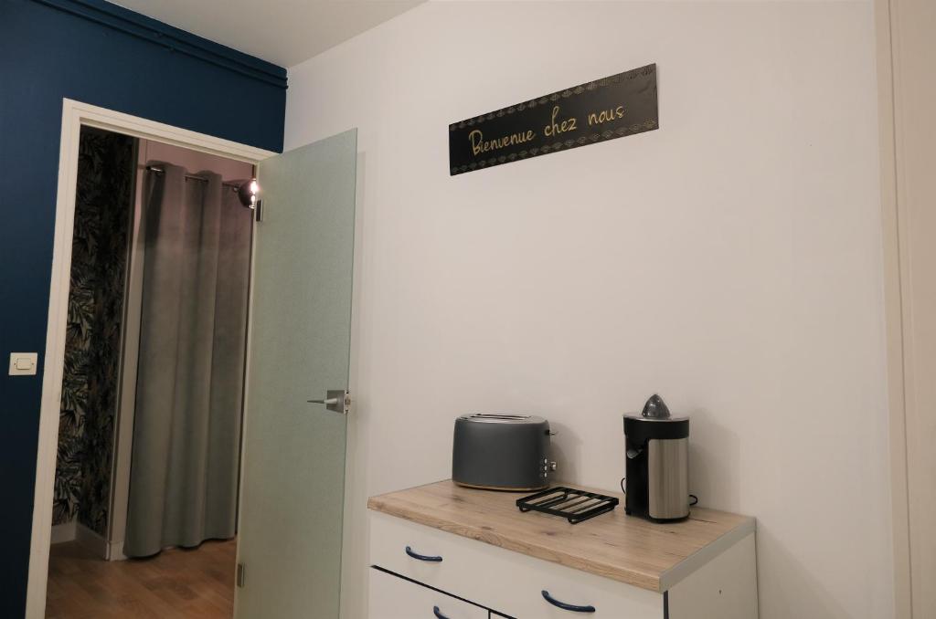 a room with a table and a sign on the wall at Le Jockey - SIPCO Immobilier - Centre in Saint Lo