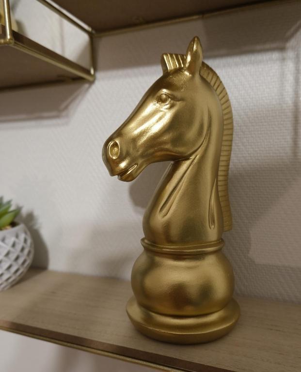 a gold horse statue sitting on a shelf at Le Jockey - SIPCO Immobilier - Centre in Saint Lo