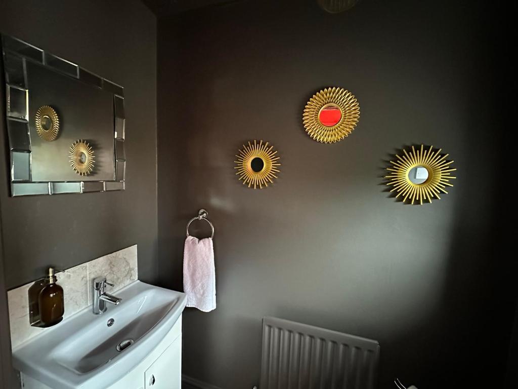 a bathroom with a sink and three mirrors on the wall at Orchard House - Great Design, Comfortable furnitures, Free Wifi & Free Parking, Nice tidy Garden in Swindon