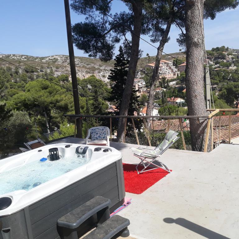 un bain à remous et une chaise assise sur un tapis rouge dans l'établissement Villa Nicole avec Spa professionnel, à Carry-le-Rouet