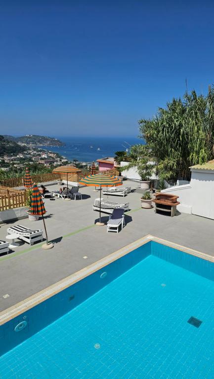 a blue swimming pool with a view of the ocean at Appartamento e piscina condivisa ISIDE in Ischia
