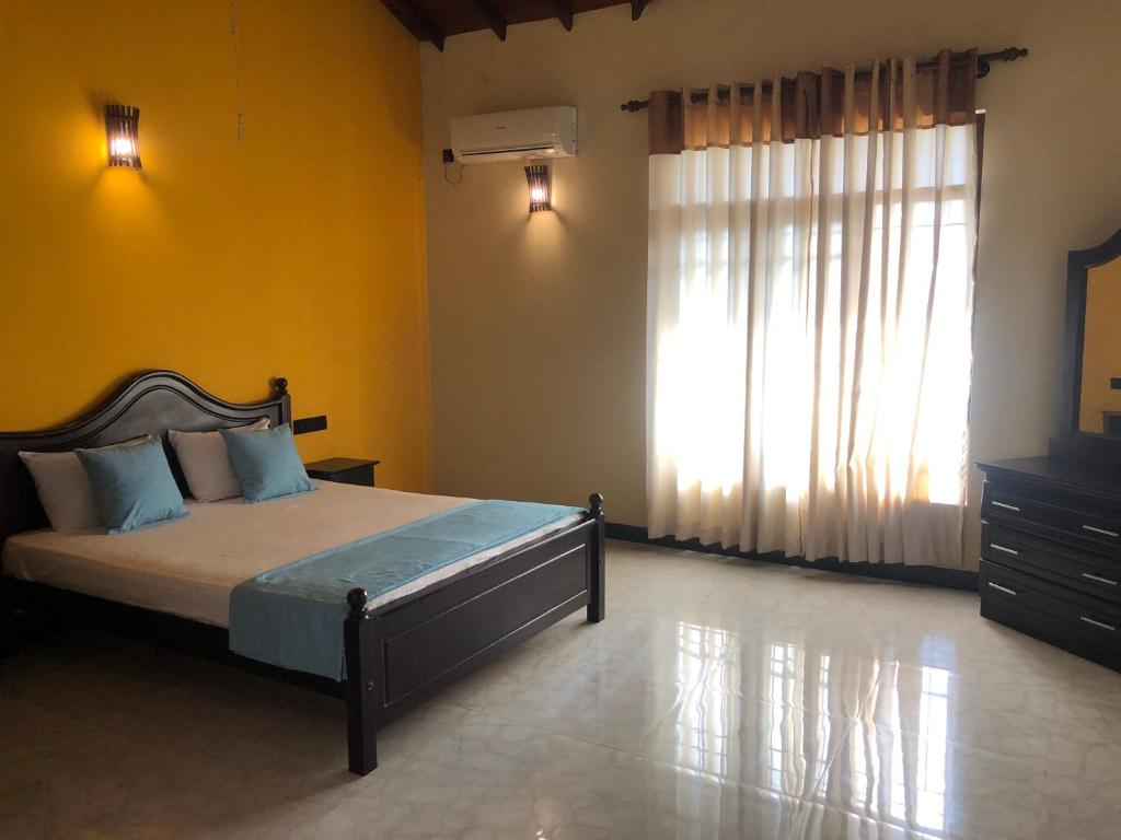 a bedroom with a bed and a large window at Sun Star Villa Negombo in Daluwekotuwa