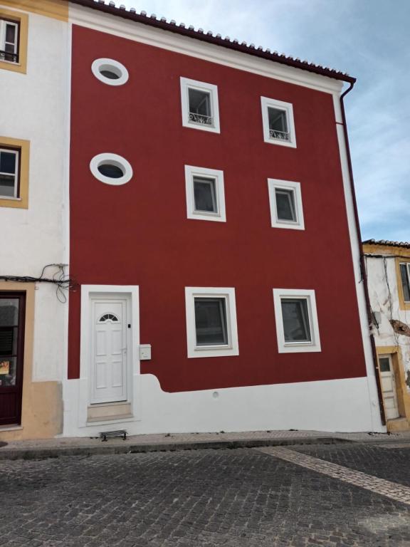 ein rot-weißes Gebäude mit einer weißen Tür in der Unterkunft Casa Ocre Alojamento Local in Abrantes