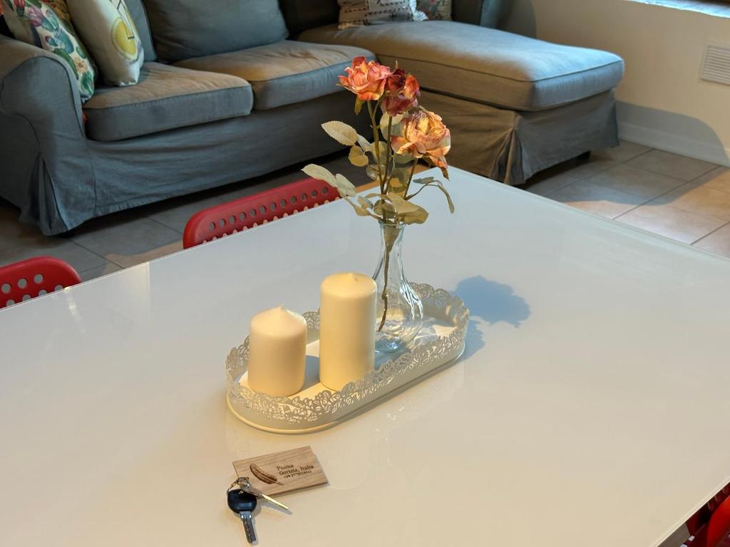 un vase avec des fleurs et des bougies sur une table dans l'établissement Piuma apartment, à Gorizia