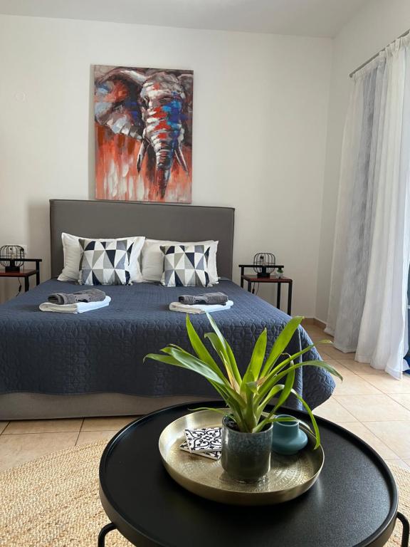 LivadiaにあるElefanti Naniのベッドルーム1室(ベッド1台、植物のあるテーブル付)