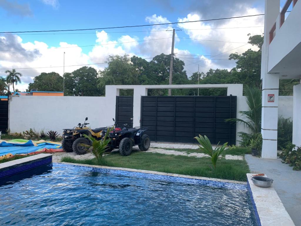 een atv geparkeerd voor een huis met een zwembad bij VILLA GRANDEZZA in Punta Cana