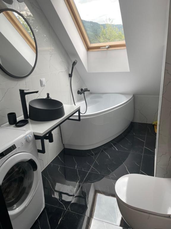 a bathroom with a sink and a washing machine at Apartament w górach in Mszana Dolna