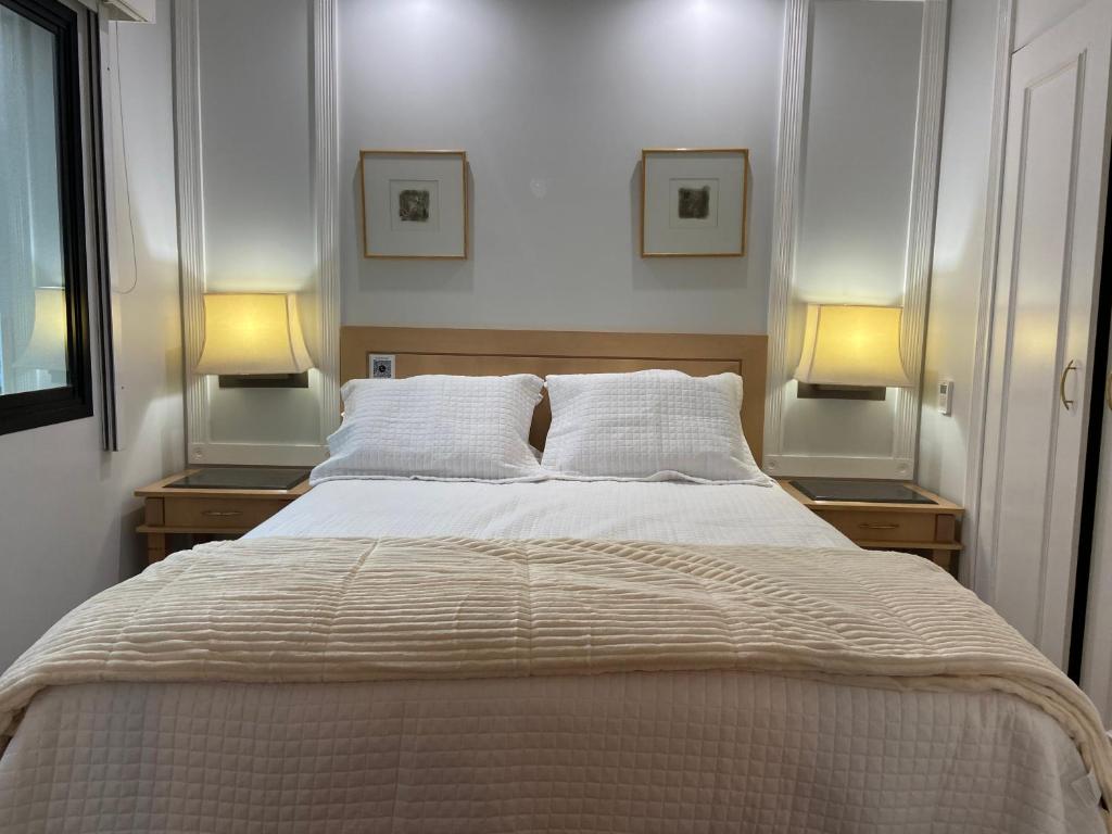 sypialnia z dużym łóżkiem z dwoma lampami po obu stronach w obiekcie Flat incrível próximo a Paulista w São Paulo