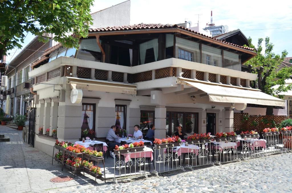 a building with tables and chairs in front of a building at Garni Hotel Le Petit Piaf in Belgrade