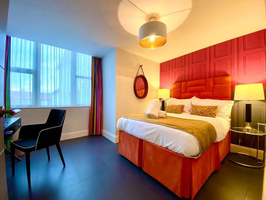 1 dormitorio con cama, escritorio y silla en Incredible Apartment - Amazing Location - Free Parking & WiFi! en Poole