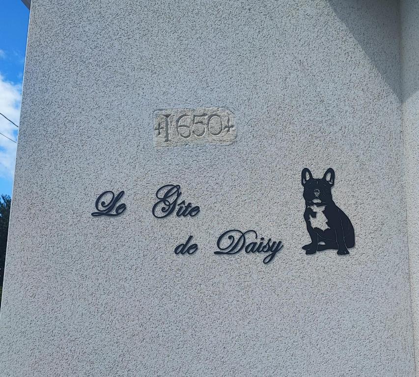 un panneau avec un chien sur le côté du bâtiment dans l&#39;établissement Le Gîte de Daisy, à Saint-Côme-du-Mont