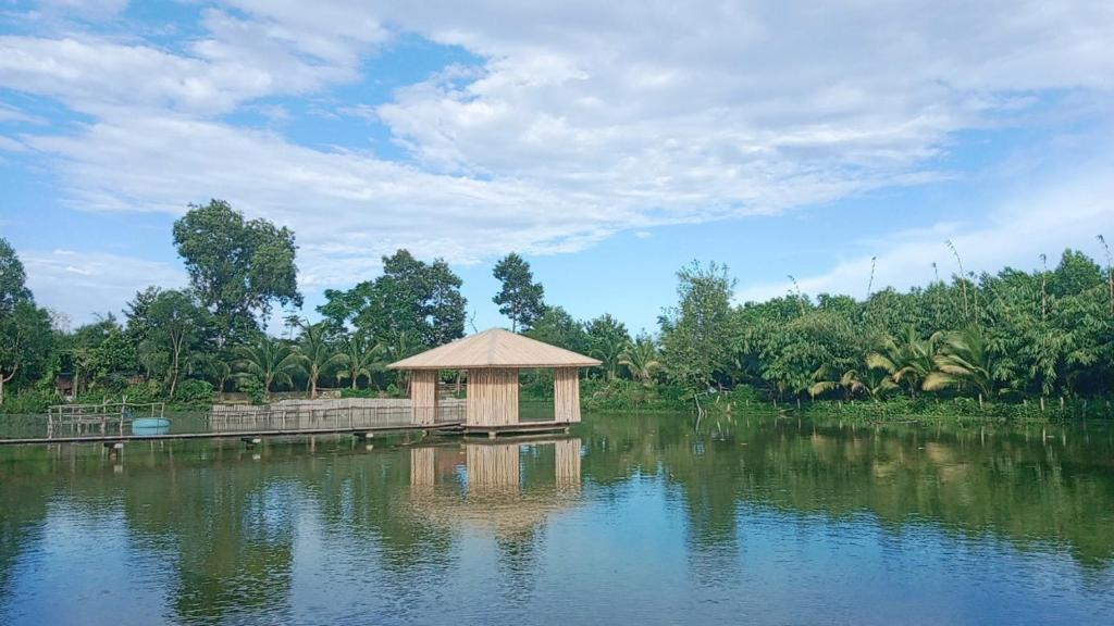 un pequeño edificio en medio de un cuerpo de agua en TINA LAKESIDE AO ĐÔI Homestay Phước Hải, en Hội Mỹ