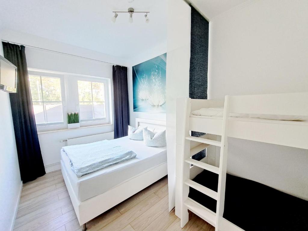 1 dormitorio con 2 literas y espejo en Zur Alten Post Prora en Binz