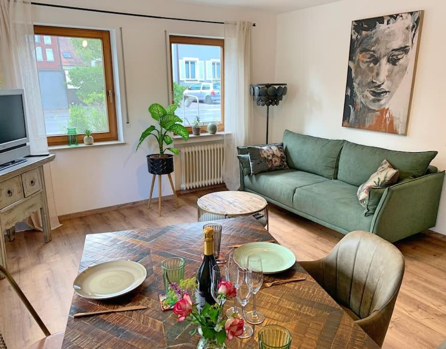 uma sala de estar com um sofá verde e uma mesa em Ferienwohnung am Bodensee em Singen