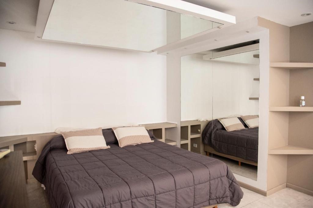 - une chambre avec un lit et un miroir dans l'établissement Edificio Correa, à Mendoza