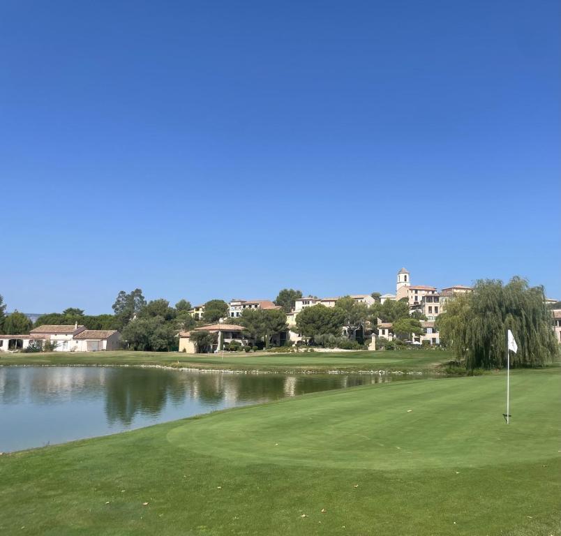 a view of a golf course with a lake at LES CISTES in Mallemort