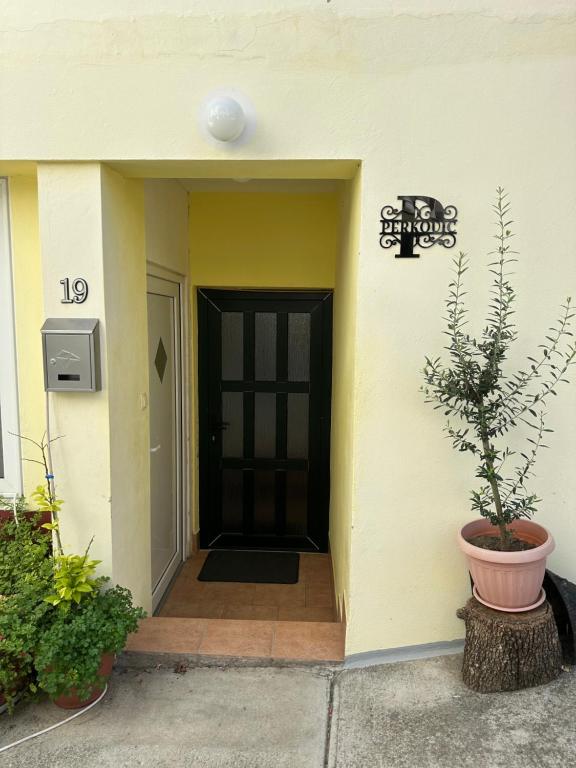 einen Eingang zu einem Gebäude mit einer schwarzen Tür in der Unterkunft apartment for 4-6 Persons second floor in Ljubač