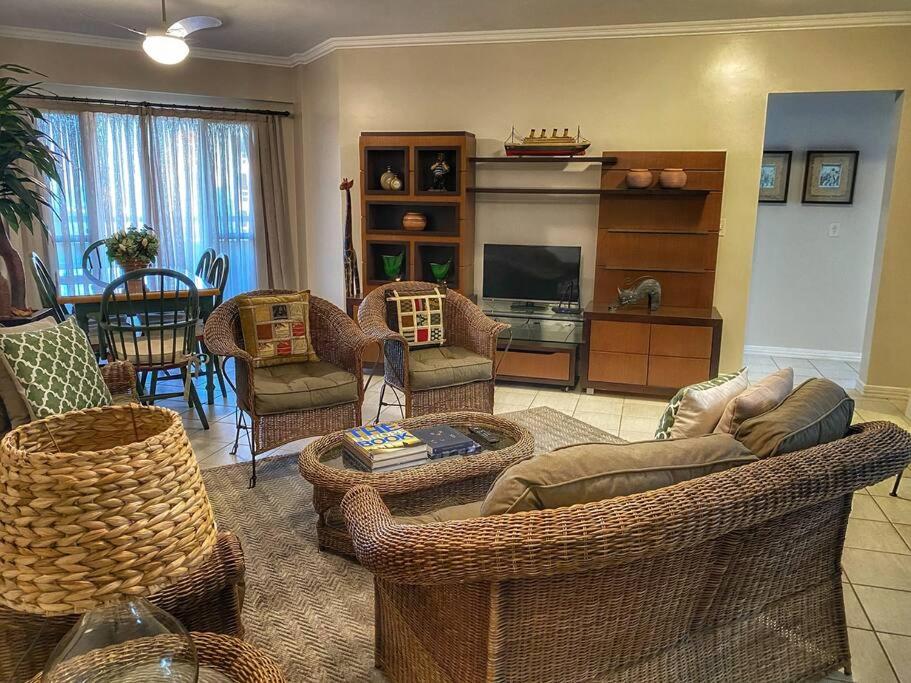 a living room with wicker chairs and a couch at Apto Praia Mariscal in Bombinhas