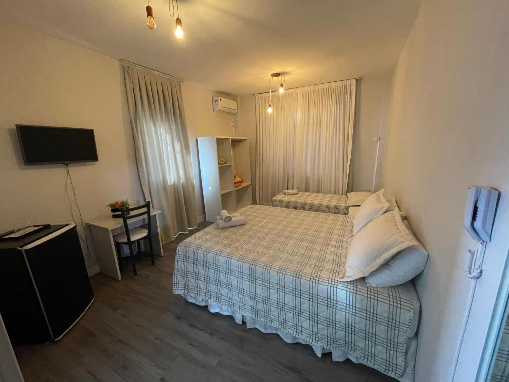 a hotel room with a bed and a television at Shallom Hotel in Balneário Camboriú