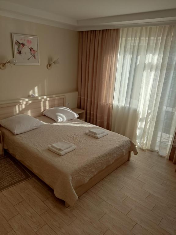 a bedroom with a bed with two towels on it at Золота Поляна in Polyana