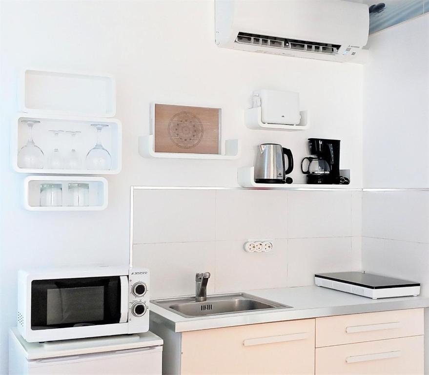 a kitchen with a sink and a microwave at Mandala Bungalows - Adults Only in Los Caños de Meca
