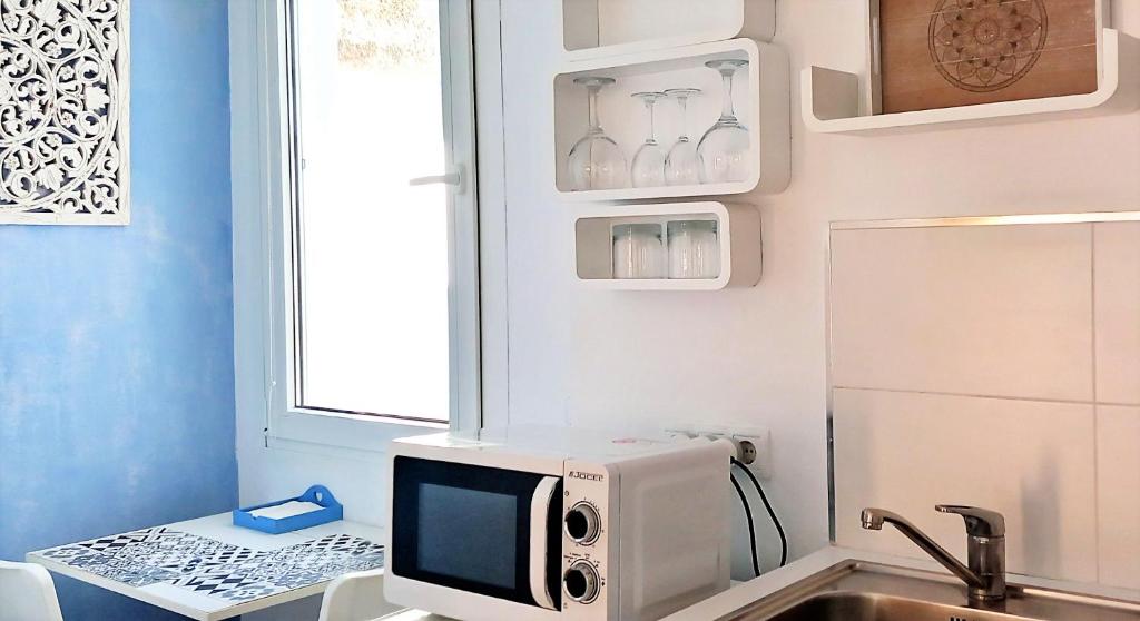 a kitchen with a microwave and a sink at Mandala Bungalows - Adults Only in Los Caños de Meca
