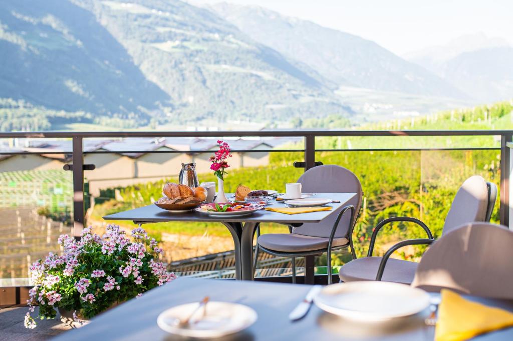 a table on a balcony with a view of mountains at Pension Apartments Pardell in Kastelbell-Tschars